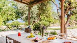 An outdoor dining area with a table set for a meal, surrounded by trees and a view of the landscape. - Authentic Sicilian Charm With Pool, Sea View, Parking & Wifi (Avola)