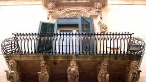 A balcony with ornate metal railings and decorative stone carvings. - Authentic Sicilian Charm With Pool, Sea View, Parking & Wifi (Avola)