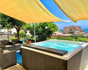 A hot tub with wicker furniture and a view of the sea. - Eden Holiday Apartment (Minori)