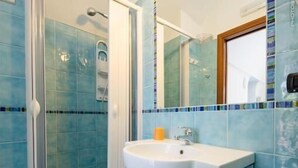 A bathroom with a shower, a sink, and a mirror. - Eden Holiday Apartment (Minori)