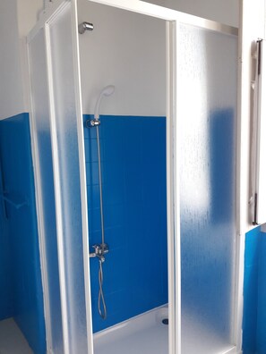Eine Duschkabine mit einer weißen Tür und blauen Wänden.
