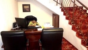 A room with a desk, two chairs, a computer, and a staircase with a red carpet. - Room-adanma Hotel and Suites - Guest Roo (Abuja)