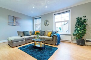 Apartamento, 2 habitaciones | Zona de estar | Una televisión, libros