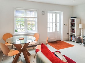 Relax in this inviting living room with a glass-top dining table and comfortable seating for four.