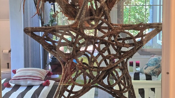 Adorno colgante con forma de estrella hecho de ramas y ramitas.