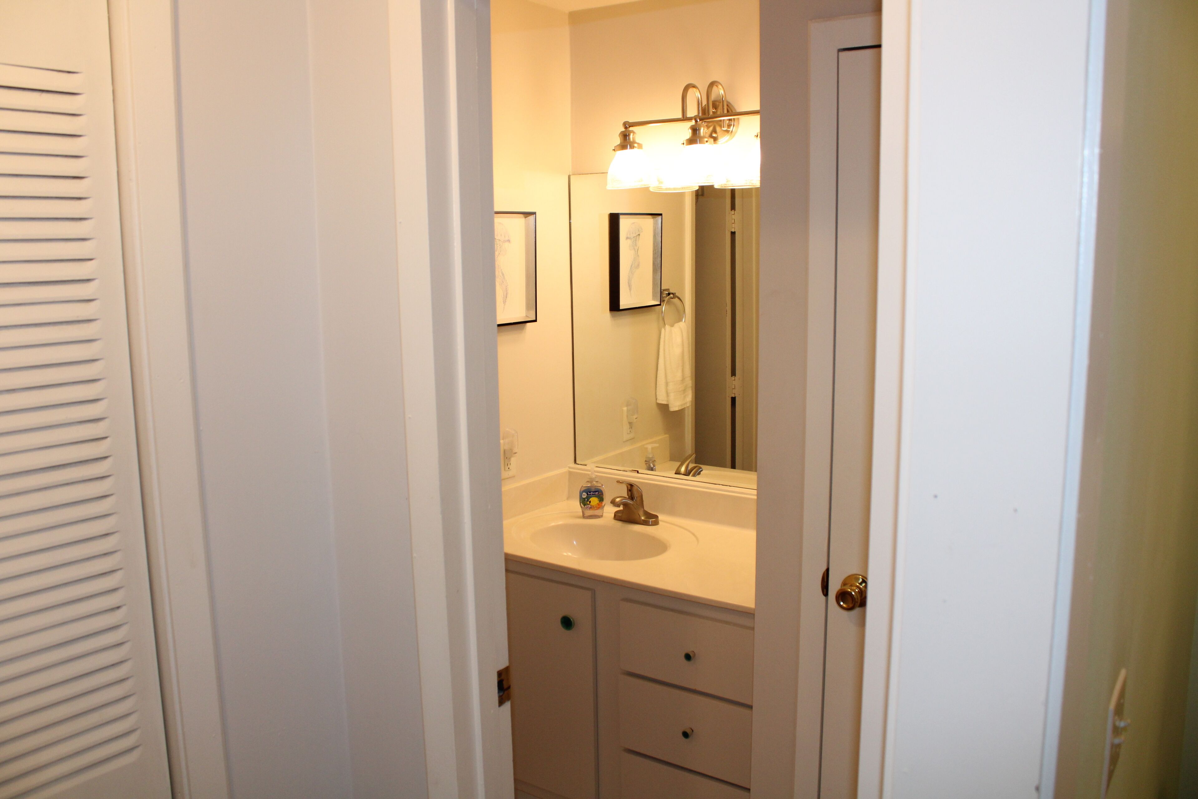 A bathroom with a sink, mirror, and two drawers.