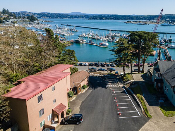 A marina with boats, a crane, and a parking lot with cars. - Yaquina Bay & Bridge Views! Watch the Boats! Full Kitchen - a culinary delight! (Newport)