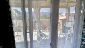 A room with a view through sheer curtains to an outdoor seating area with chairs and tables. - THE WONDER Legalized VUT-LE-533 (Tedejo Folgoso de la Ribera. león)