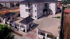 Um edifício residencial com vários andares, um pátio central, varandas e uma entrada com portão.