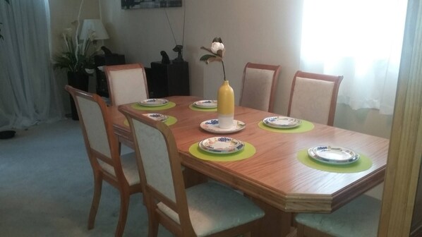 A dining table with six chairs, a vase with a flower, and plates on placemats. - Big House for Share Near 401-east And Pickering Town Centre (Pickering)