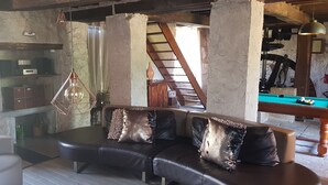 A cozy living area with a leather sofa, a pool table, and a rustic staircase. - Renovated 18th century mill "Domaine vous uniquement vous, with private swimming pool". (Montapas)