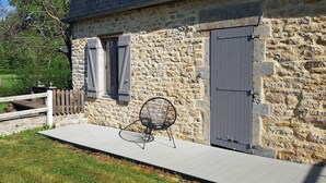 A stone building with a wooden deck, a chair, and a gate. - Renovated 18th century mill "Domaine vous uniquement vous, with private swimming pool". (Montapas)