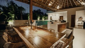Ein Holzespeisesaal mit Stühlen, einer Küchenzeile und einem Pool.