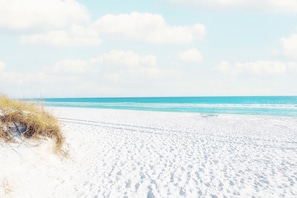 A beach with white sand and a clear blue sky.