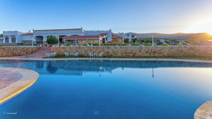 Un complexe hôtelier doté d’une piscine, d’un espace extérieur aménagé et offrant une vue sur les montagnes.