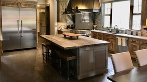 Una cocina moderna con una isla central, electrodomésticos de acero inoxidable y un amplio ventanal que proporciona luz natural.