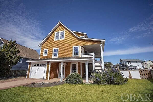A two-story house with a front porch, a garage, and a small front yard.