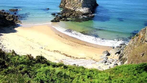 A coastal beach with clear waters, a sandy shore, and a prominent rock formation. - Stunning ocean views, Sunsets and just 30 seconds from the Beach! (GA)
