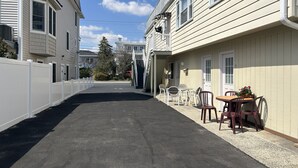 Ein schmaler Zugangsweg führt zu einem Gebäude mit einer überdachten Terrasse.