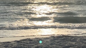 A beach with sunlight reflecting off the water.