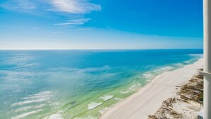 A beach with clear blue water and a sandy shore.