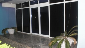 A building exterior with large glass doors, a tiled floor, and potted plants. - Room-royalrex Hotel-guest Room (Lagos)