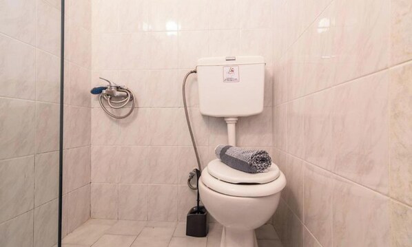 A modern bathroom with a toilet, a shower, and a glass-enclosed shower area. - "room in Guest Room - Girogiali Beach Hotel" (Chania)