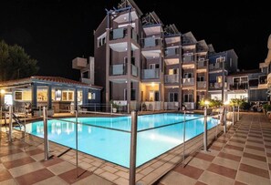 A multi-story hotel with a swimming pool, outdoor seating, and a covered area with a bar. - "room in Guest Room - Girogiali Beach Hotel" (Chania)