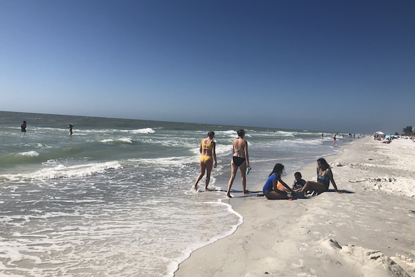 Una playa cerca, sillas reclinables de playa, toallas de playa