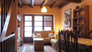 A cozy room with a wooden staircase, a sofa, a small table, and a bookshelf.