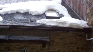 A stone building with a wooden door, a number '16E' above the door, and a wreath hanging on the door.