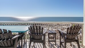 A deck with a glass table and Adirondack chairs overlooking a beach. - BEACHFRONT CONDO IN THE CATALINA TOWER, BEACH CLUB, GULF SHORES!!!!! (Gulf Shores)