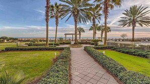 A pathway lined with palm trees and a gazebo, leading to a beach. - BEACHFRONT CONDO IN THE CATALINA TOWER, BEACH CLUB, GULF SHORES!!!!! (Gulf Shores)