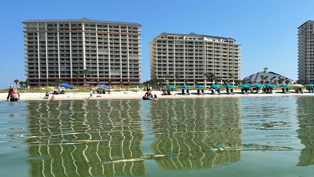 A beachfront hotel with multiple high-rise buildings, sandy beach, and clear water reflecting the structures. - BEACHFRONT CONDO IN THE CATALINA TOWER, BEACH CLUB, GULF SHORES!!!!! (Gulf Shores)