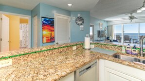 A kitchen with granite countertops, a dishwasher, and a view of the ocean through large windows. - BEACHFRONT CONDO IN THE CATALINA TOWER, BEACH CLUB, GULF SHORES!!!!! (Gulf Shores)