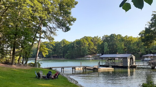 Un parc au bord du lac, doté d’une pelouse, d’un quai et d’une petite construction en bois.