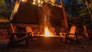 A modern cabin with a fire pit and Adirondack chairs in front. - Perfect for Couples,2 King Master bedrooms, Dry Sauna, Hot Tub, 3 covered decks (Broken Bow)
