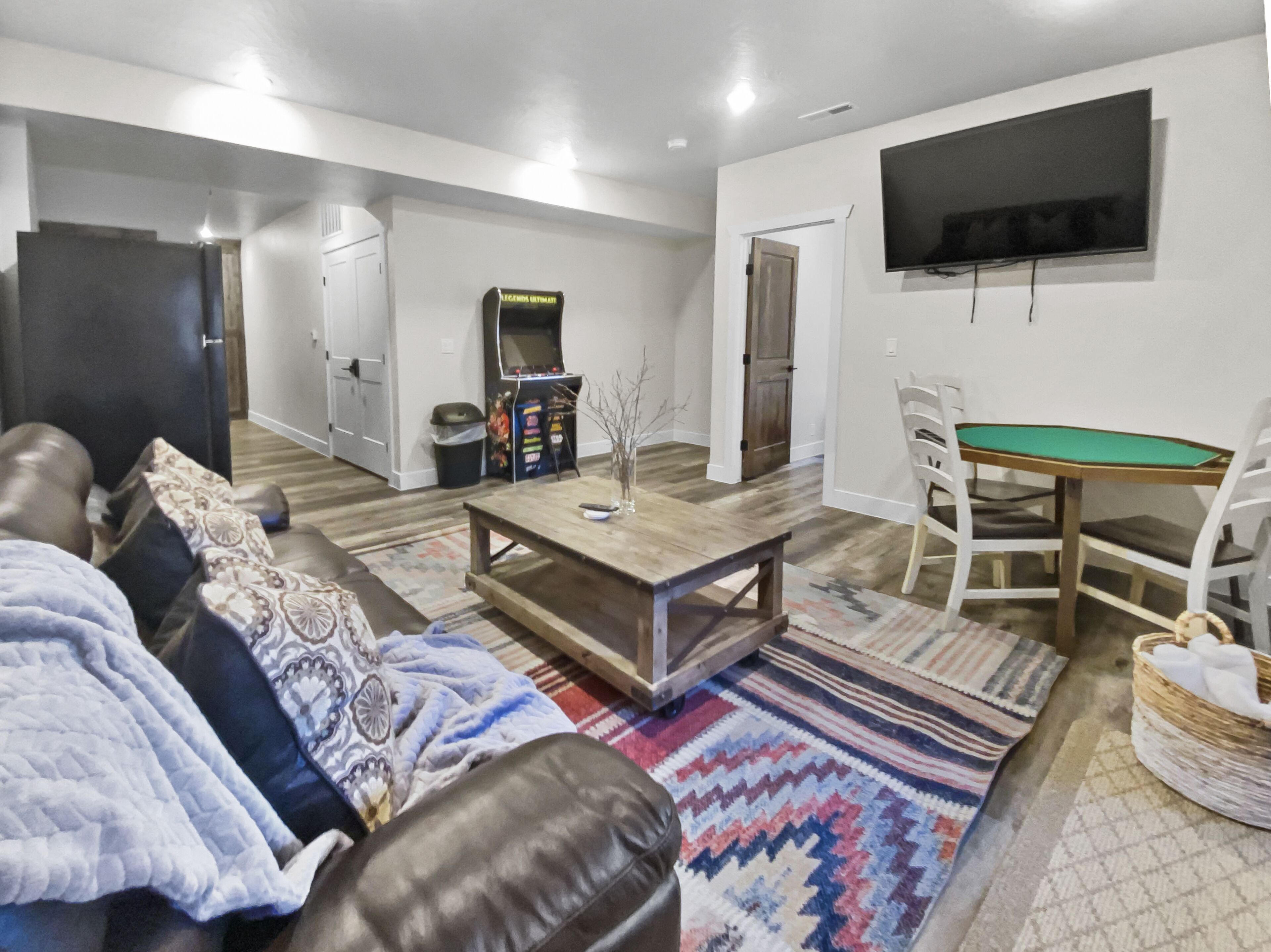 A living room with a sofa, coffee table, and a television mounted on the wall.