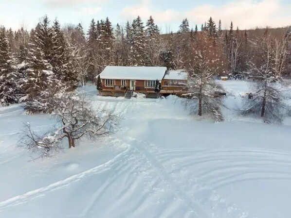 A cabin surrounded by snow-covered trees. - Le Sommet, 25 min from Tremblant with SPA (Labelle)