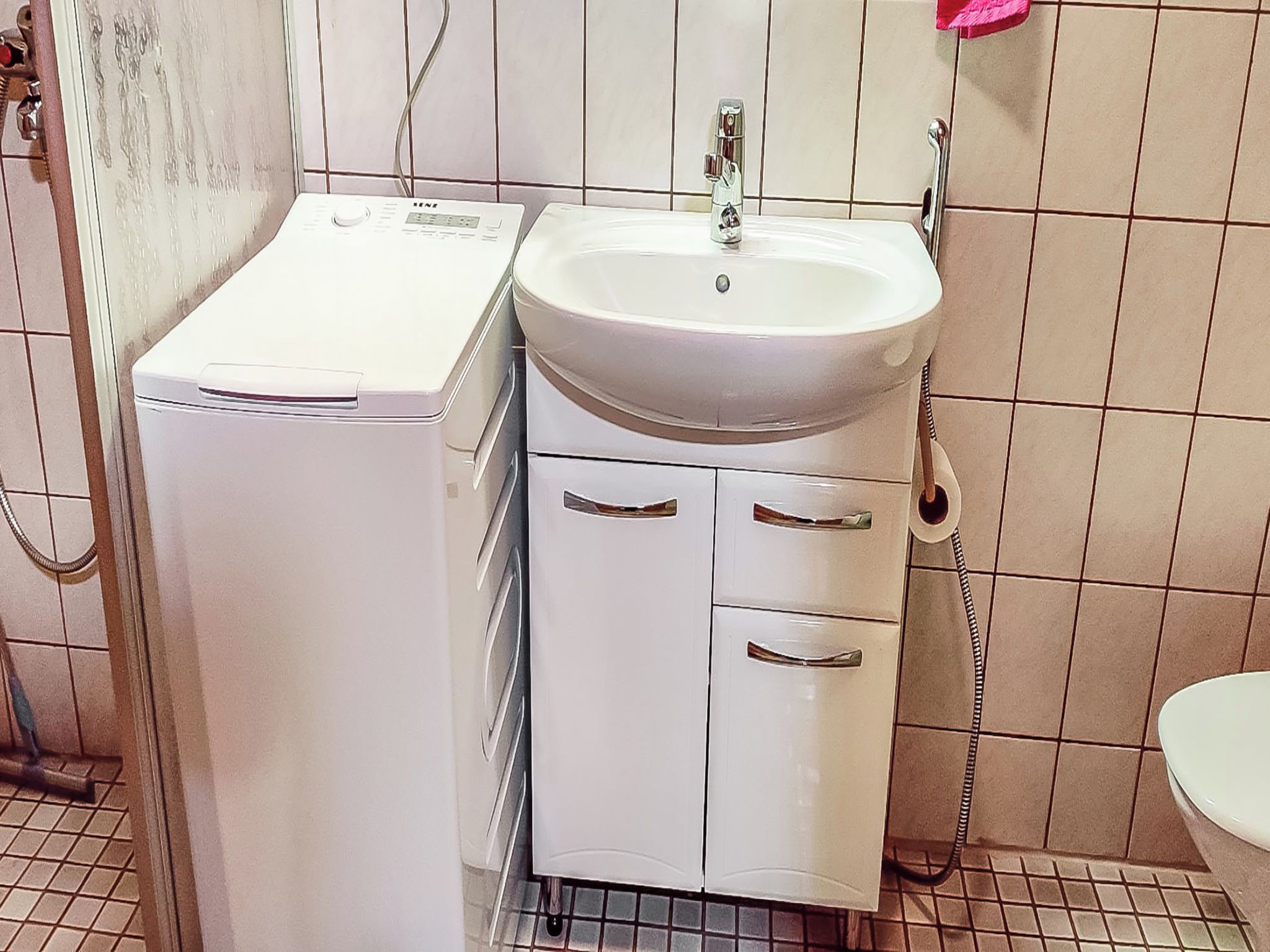 A bathroom with a white sink, a mirror, and a toilet.