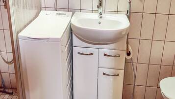 Ein Badezimmer mit einem weißen Waschbecken, einem Spiegel und einer Toilette.