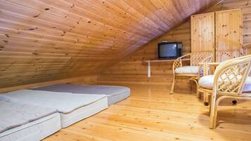 Quarto de sótão aconchegante, com paredes de madeira e teto inclinado.