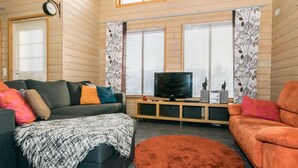 A cozy living room with a sofa, a television, and a fireplace. - Rinteenkotka mökki by Interhome (Hyrynsalmi)