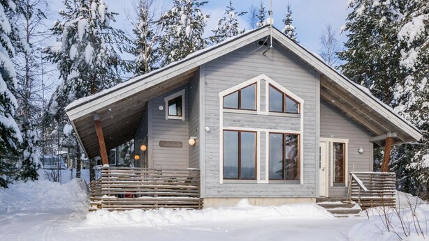 A cabin with a sloped roof, large windows, and a wooden deck. - Rinteenkotka mökki by Interhome (Hyrynsalmi)