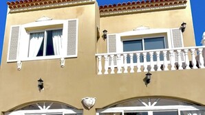 A building with two balconies, white railings, and a beige facade. - Villa - Sleeps 4 - Jacuzzi - Garden - Pet friendly (El Medano)
