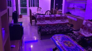 Ein Zimmer mit Esstisch, Stühlen, einer Couch und einem Fernseher.