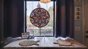 A room with a large stained glass window, a Wi-Fi sign, and two woven placemats on the table. - Spacious and Tranquil Lazy Lake Lodge Escape (Lake Ariel)