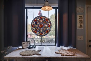 Enjoy a view of the balcony from the circular stained glass window, with a table and seating area below.