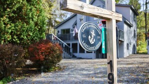 A wooden sign with a circular emblem for Glenwood Lake Lodge, including the year 1945 and a logo. - Spacious and Tranquil Lazy Lake Lodge Escape (Lake Ariel)