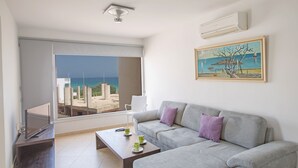 Una sala moderna con un sofá gris, una mesa de centro y un cuadro en la pared.